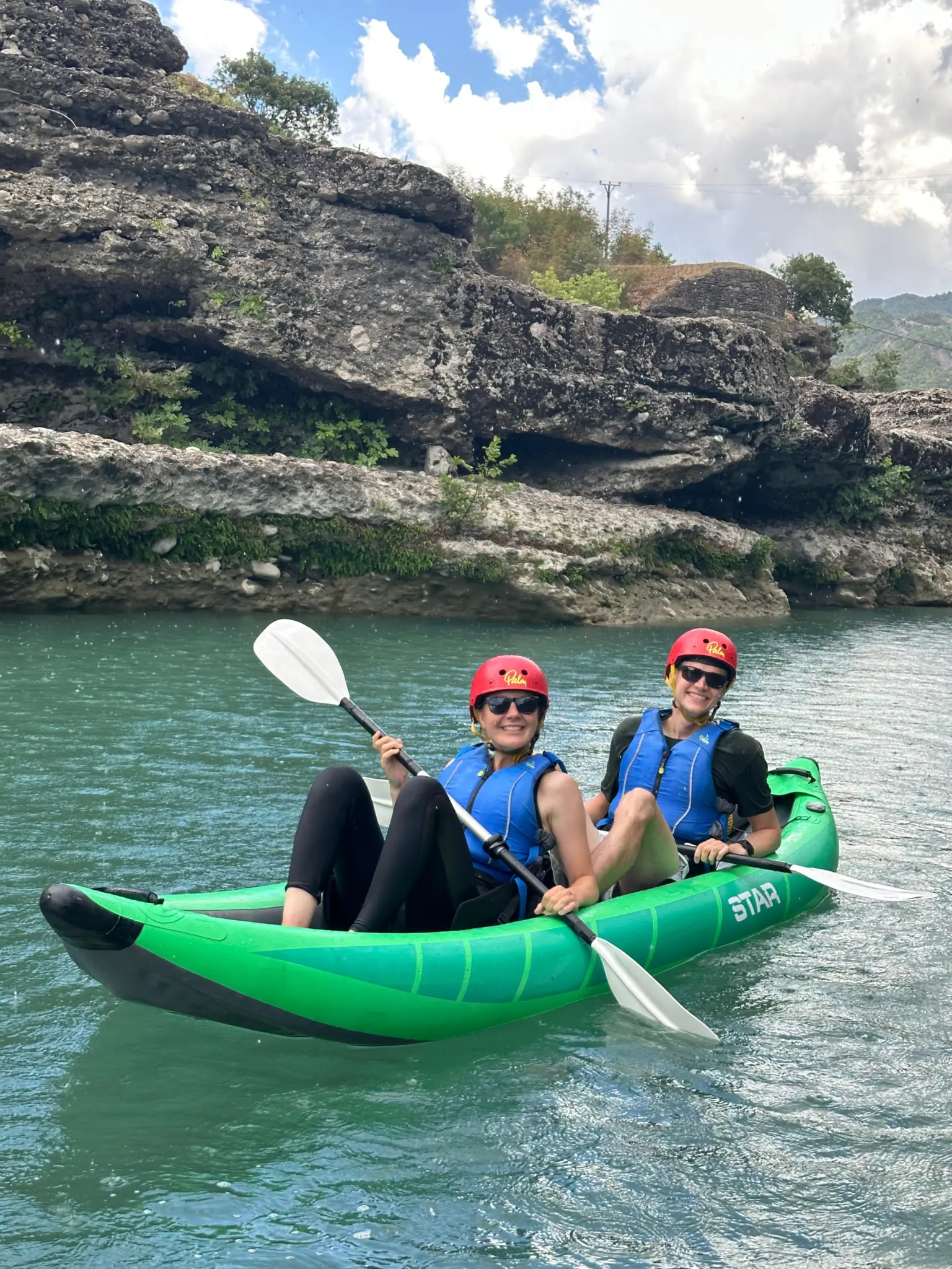 Two guests in a green inflatable kayak on the Vjosa near Përmet