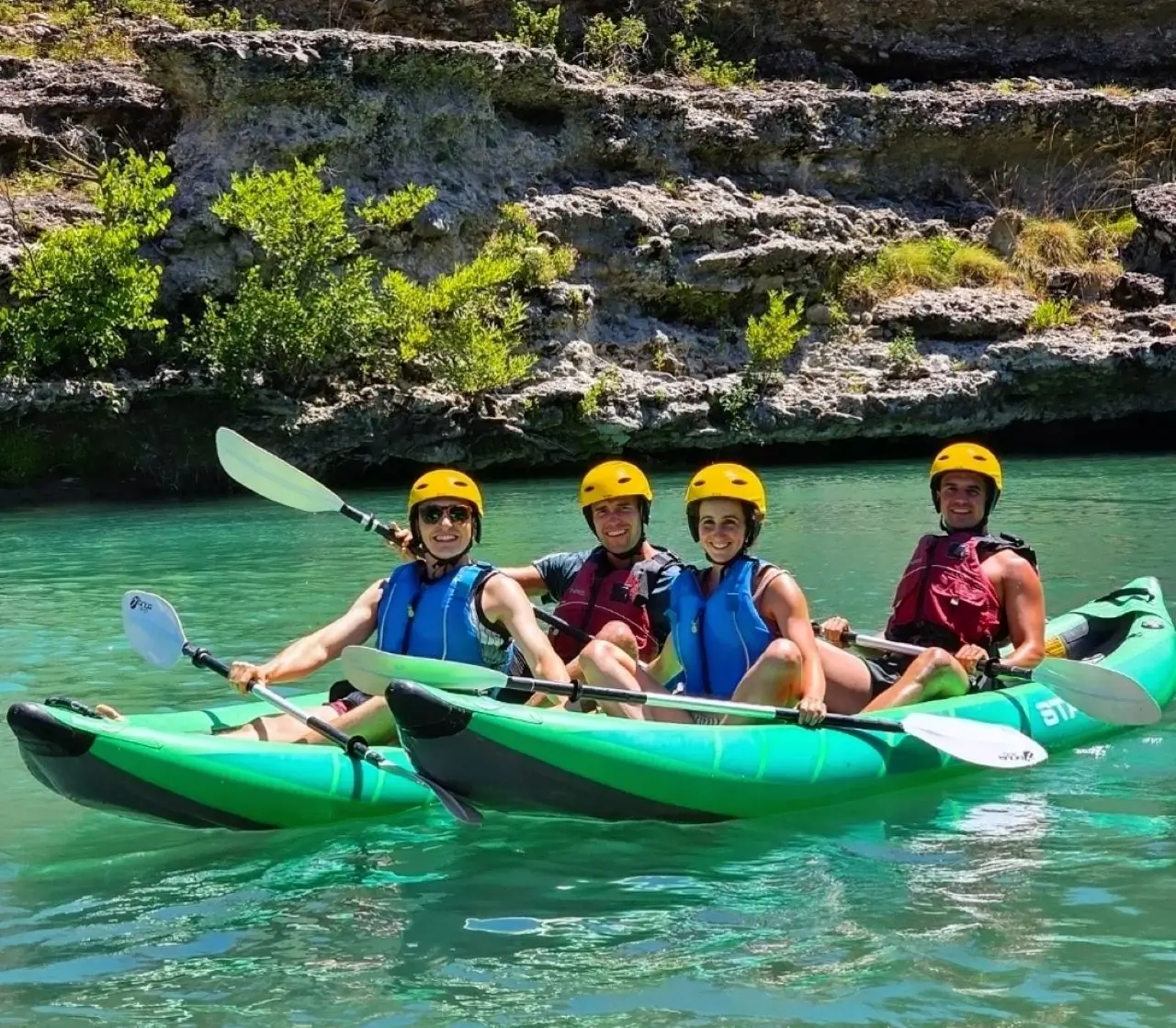 Four kayakers in two tandem kayaks on the Vjosa, alongside the rafting departure