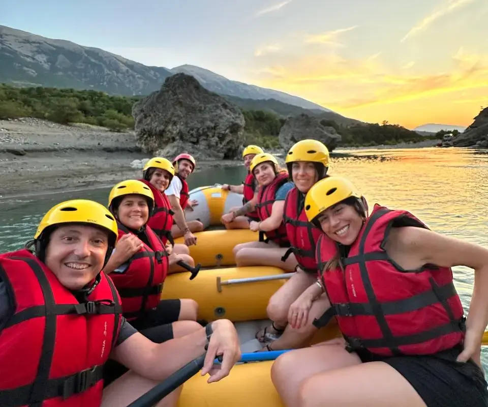Fotos von der Vjosa 11 Yellow raft with guests in red life jackets on the Vjosa at sunset