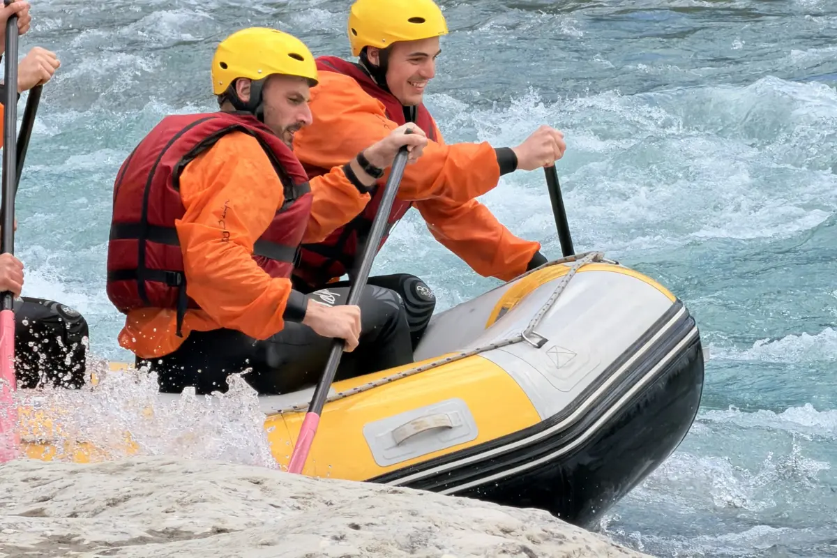 Fotos von der Vjosa 4 Guide and guest in orange life jackets on a raft at the edge of a Vjosa rapid