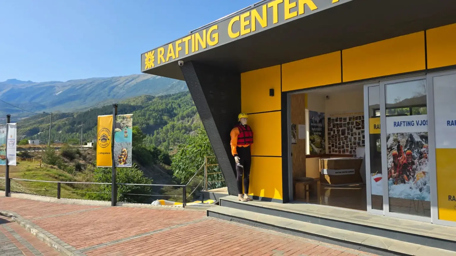 Rafting Vjosa Albania's riverside centre in Përmet with the yellow RAFTING CENTER sign